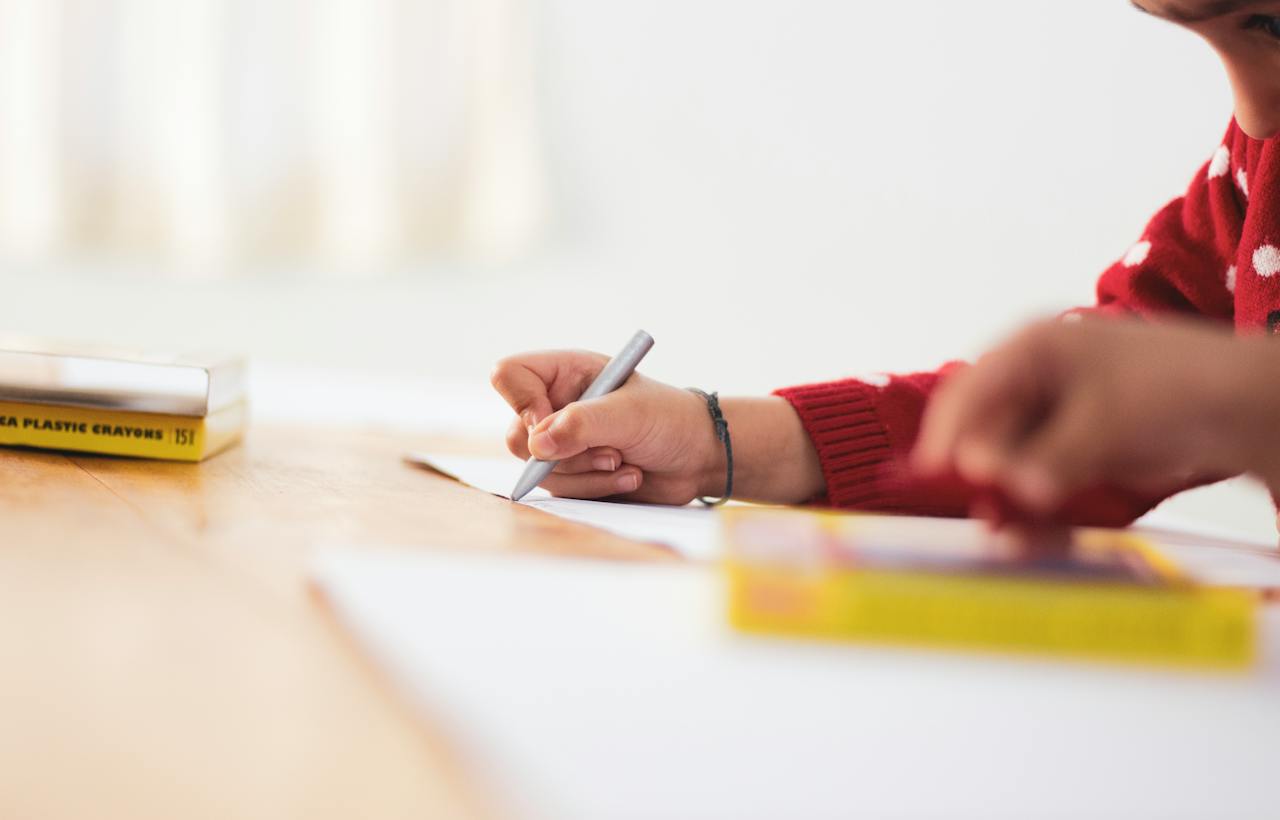 A person is sat a desk writing